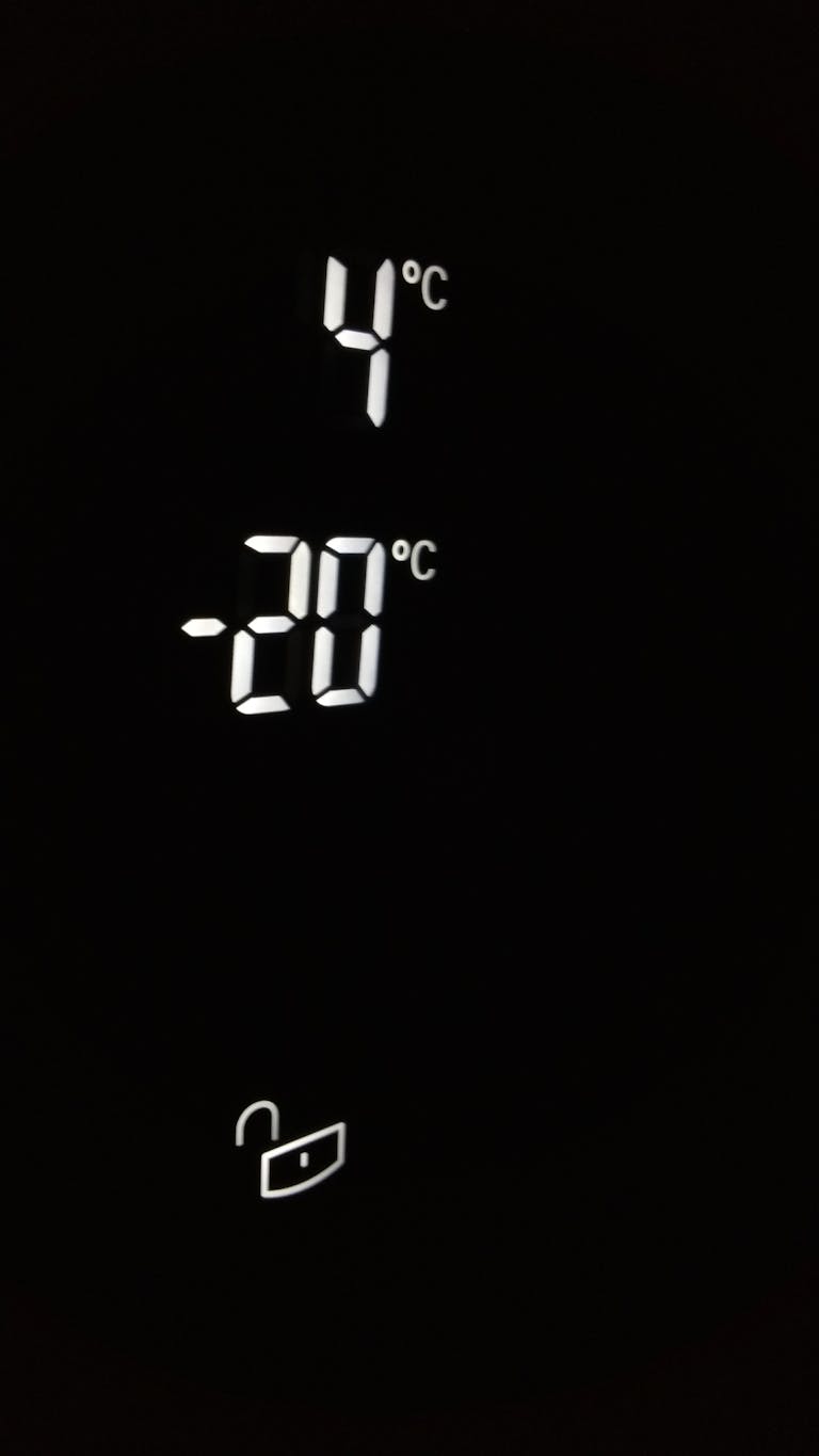Close-up of electronic screen showing 4°C and -20°C in white digits