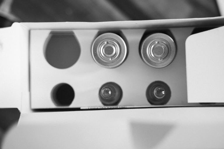Top view of open battery packaging in black and white, showcasing round cells.